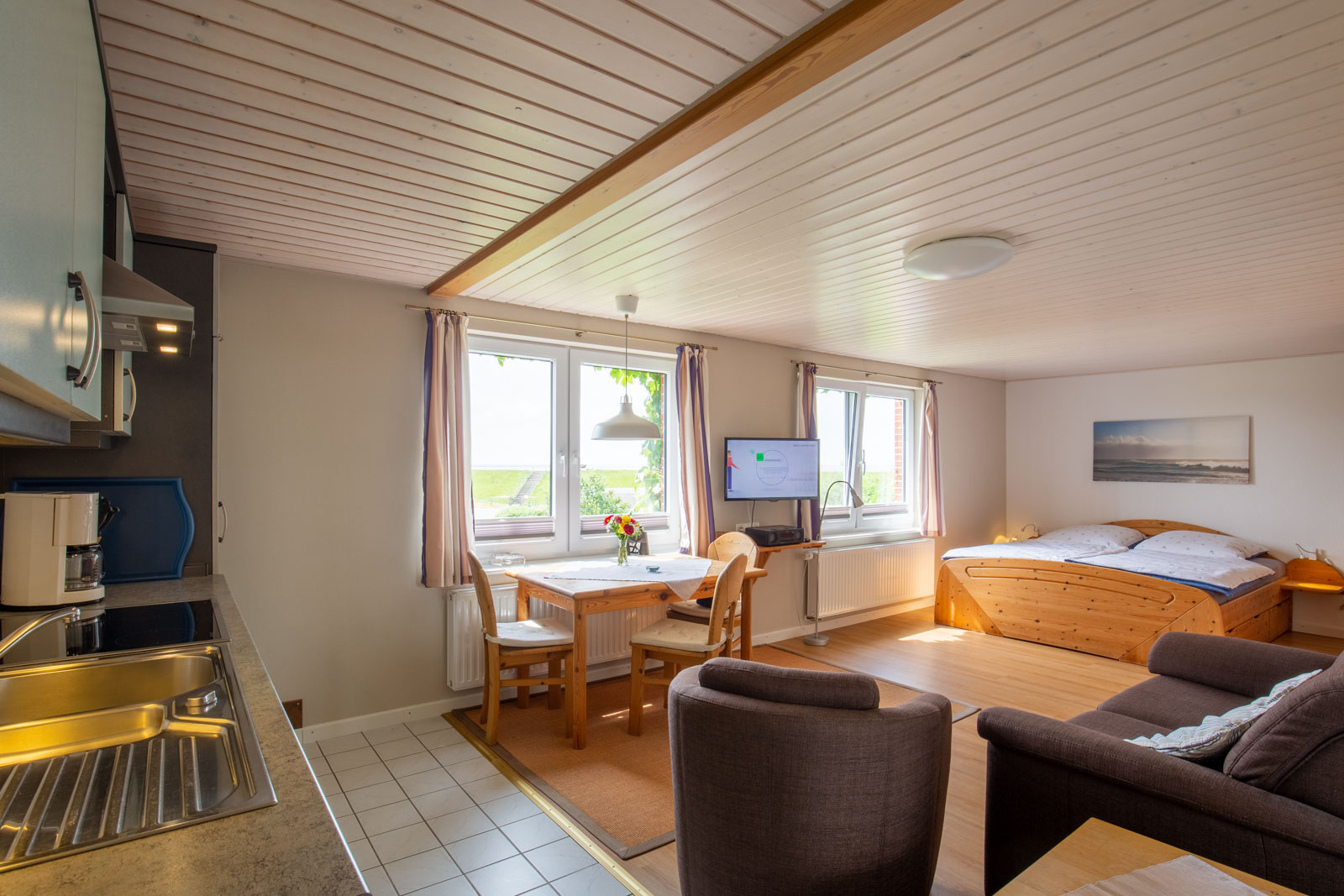 Kombinierter Wohn- und Schlafbereich des Appartements Süderoog für den Urlaub an der Nordsee auf der Nordseeinsel Pellworm mit Küchenzeile und Doppelbett