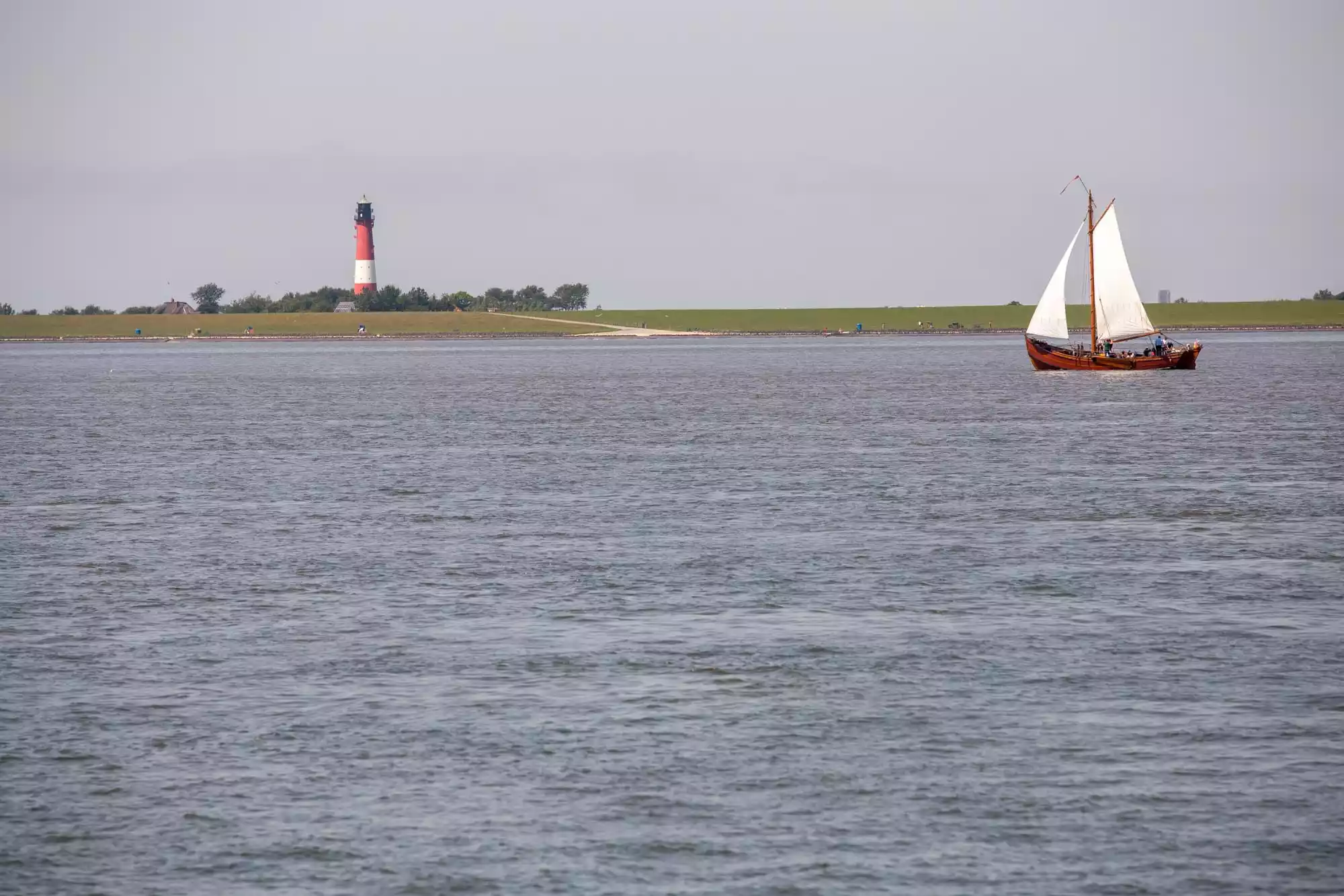 Plattbodenschiff vor dem Deich am Leuchtturmstrand Pellworm – traditionelle Schiffsfahrt im nordfriesischen Wattenmeer