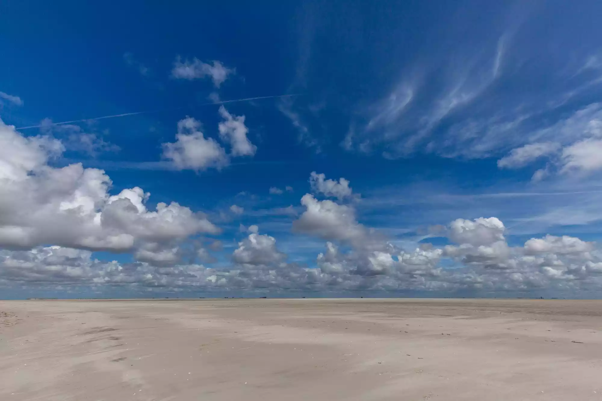 Weite Sandbank vor Pellworm mit hohem, wolkendurchzogenem Nordseehimmel – Nationalpark Schleswig-Holsteinisches Wattenmeer